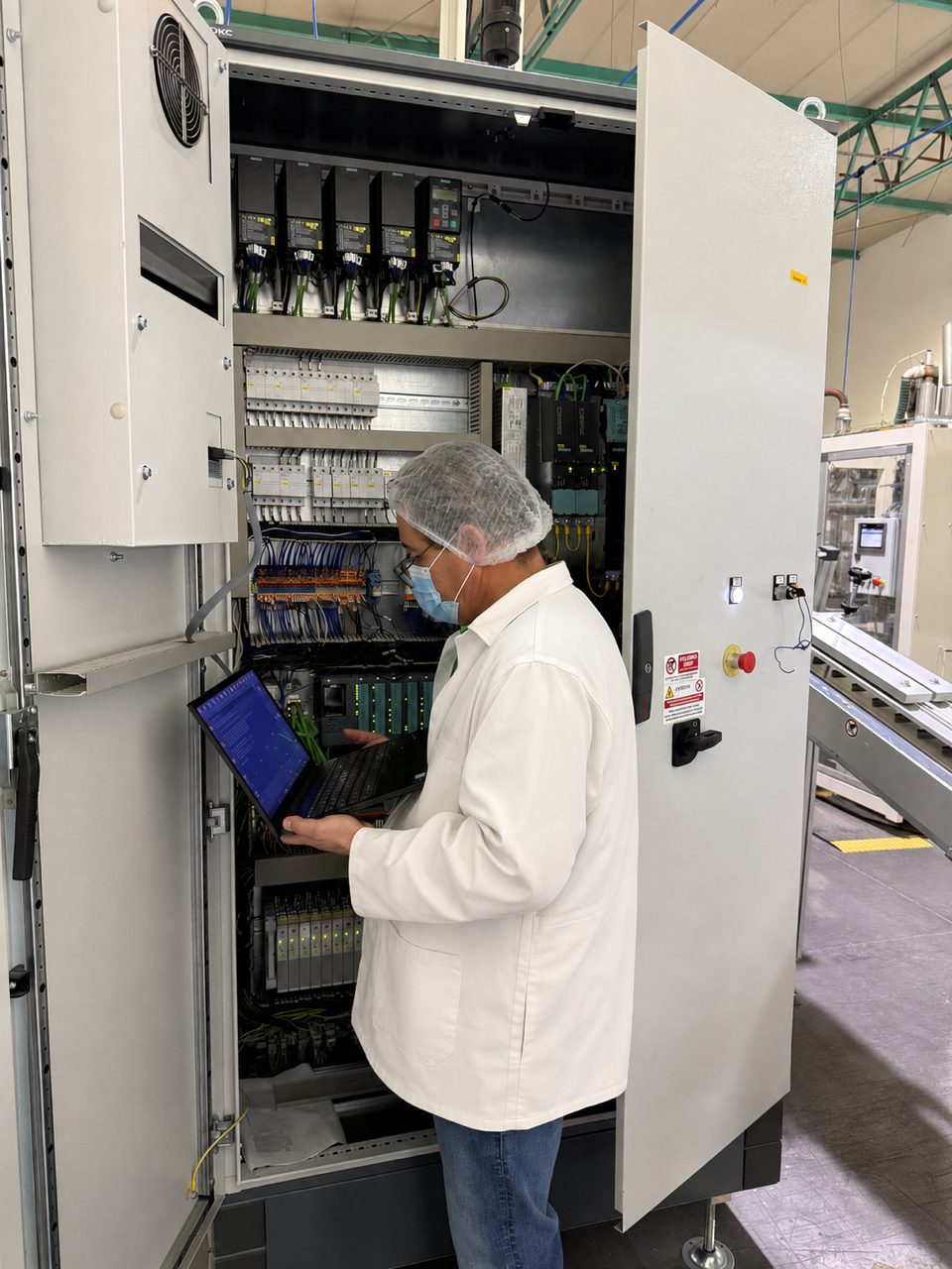 Trabajo dentro de un tablero de control industrial durante el levantamiento de una celda